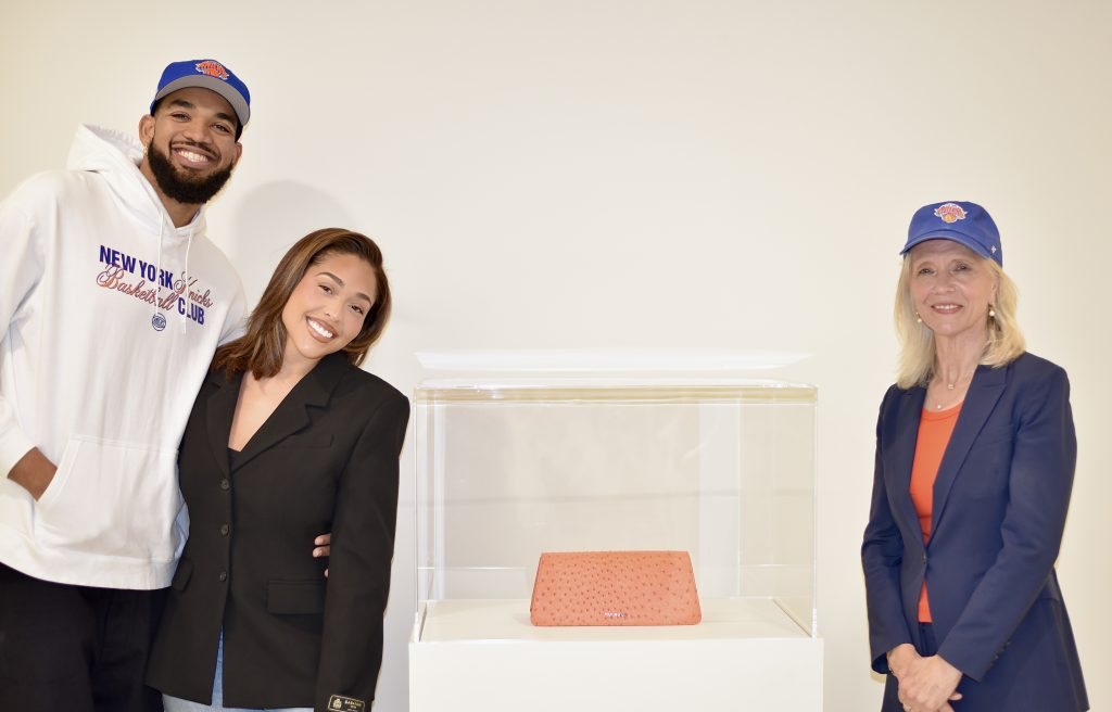 Jordyn Woods and Karl-Anthony Towns beside her orange Knicks clutch on display at the Guggenheim